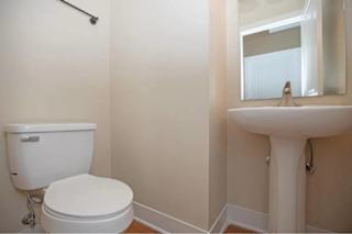 A white toilet and sink in a small bathroom.
