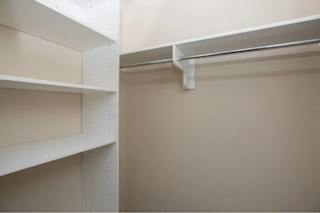 A white shelf with a metal support beam above it.