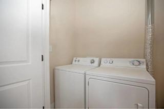 Two white washing machines in a small laundry room.