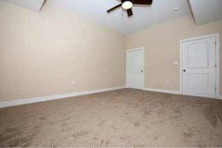 A room with a ceiling fan and two doors.