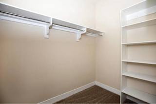 A white shelf is on the right side of a room.