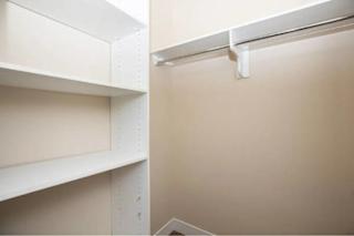 A white shelf with a white pipe running along the top.