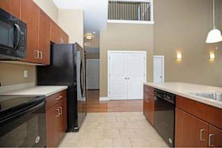 A kitchen with black appliances and brown cabinets.