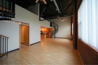 A room with wooden floors and a staircase.