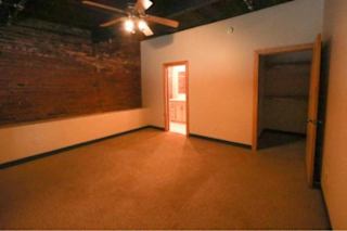A room with a ceiling fan and a door.
