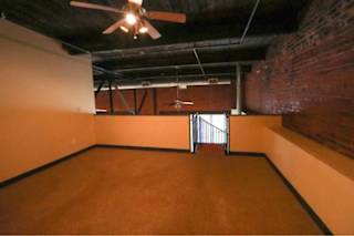 Empty room with a ceiling fan and a door.