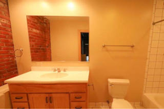 A bathroom with a white counter top and a toilet.