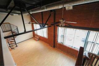 A room with a ceiling fan and a chair.