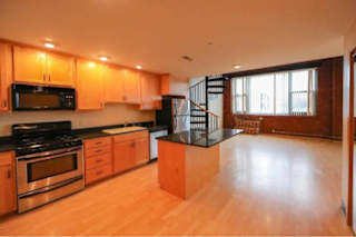 A kitchen with wooden cabinets and a black countertop.