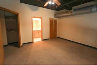 A room with a carpeted floor and a door on the left.
