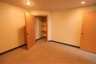 A hallway with a carpeted floor and two open doors.