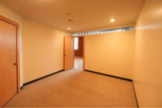 A room with a carpeted floor and a door on the left.