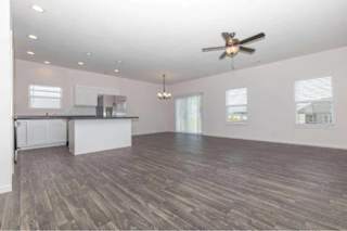 A spacious room with a ceiling fan and wooden flooring.
