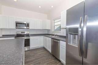 A modern kitchen with stainless steel appliances and white cabinets.