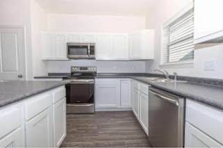 A kitchen with white cabinets and stainless steel appliances.