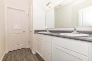 A bathroom with a sink and a mirror.