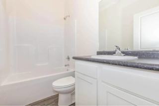 A white bathroom with a toilet, sink, and bathtub.