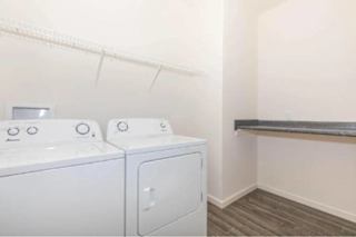 Two white front loading washing machines in a laundry room.