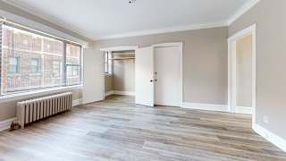 A room with a white door and a window with blinds.