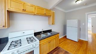 A kitchen with a white stove and wooden cabinets.