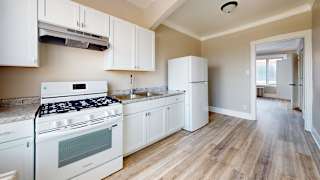 A kitchen with white appliances and cabinets.