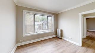 A room with a window and a radiator on the wall.
