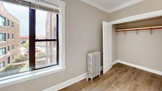 A room with a window and a radiator on the floor.