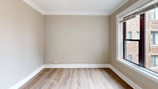 Empty room with wooden flooring and a window.