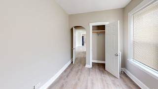A room with a white door and a window with blinds.