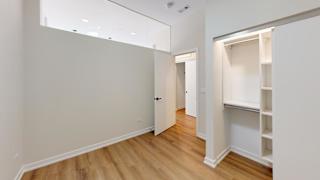 a bedroom with a closet and a hard wood floor