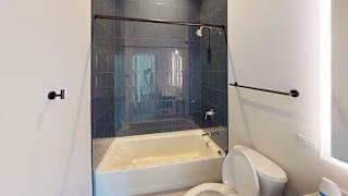 a bathroom with a tub and a toilet and a shower