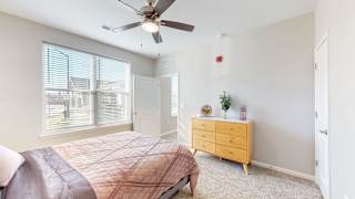 A bedroom with a bed, dresser, and window at The Slate, Jeffersonville, 47130