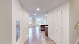 A kitchen with white cabinets and a refrigerator.