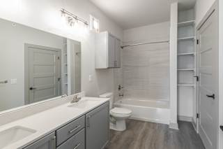 A white bathroom with a toilet, sink, and bathtub at Arbour Place Apartments, Jeffersonville, IN