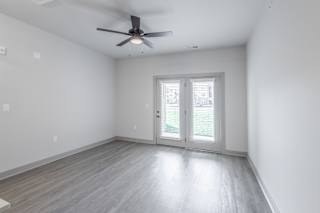 A room with a ceiling fan and sliding glass doors at Arbour Place Apartments, Jeffersonville, IN