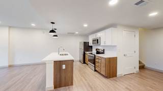 A kitchen with a white counter top and wooden cabinets.