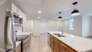 A modern kitchen with stainless steel appliances and wooden cabinets.