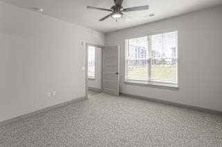 A room with a ceiling fan and a door leading to a balcony at Arbour Place Apartments, Jeffersonville, IN
