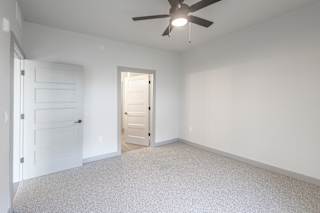 A room with a ceiling fan and two doors at Arbour Place Apartments, Jeffersonville, IN