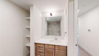 A bathroom with a sink, mirror, and wooden drawers.