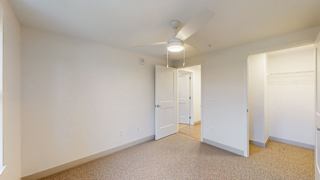 A white room with a carpet floor and a ceiling light.