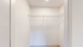 Empty white closet with a shelf.