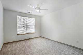 Carpeted bedroom with ceiling fan at Allure Apartments, Indiana