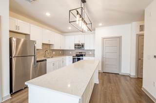 White kitchen with island and modern lighting at Allure Apartments, Whiteland, 46184