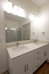 Modern bathroom with double vanity and glass shower at Allure Apartments, Whiteland