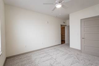 Empty carpeted room with ceiling fan and doorway at Allure Apartments, Whiteland, 46184