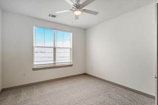 Empty carpeted bedroom with window and ceiling fan at Allure Apartments, Whiteland, Indiana