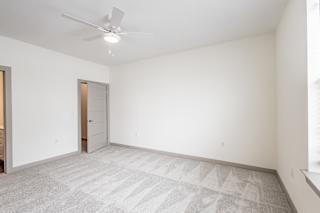 Spacious carpeted bedroom with vaulted ceiling and fan at Allure Apartments, Whiteland, IN 46184