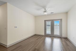 Empty living room with french doors and wood floors at Allure Apartments, Indiana, 46184