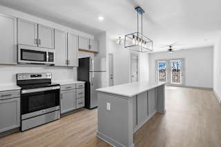 A modern kitchen with a large island and stainless steel appliances at Arbour Place Apartments, Jeffersonville